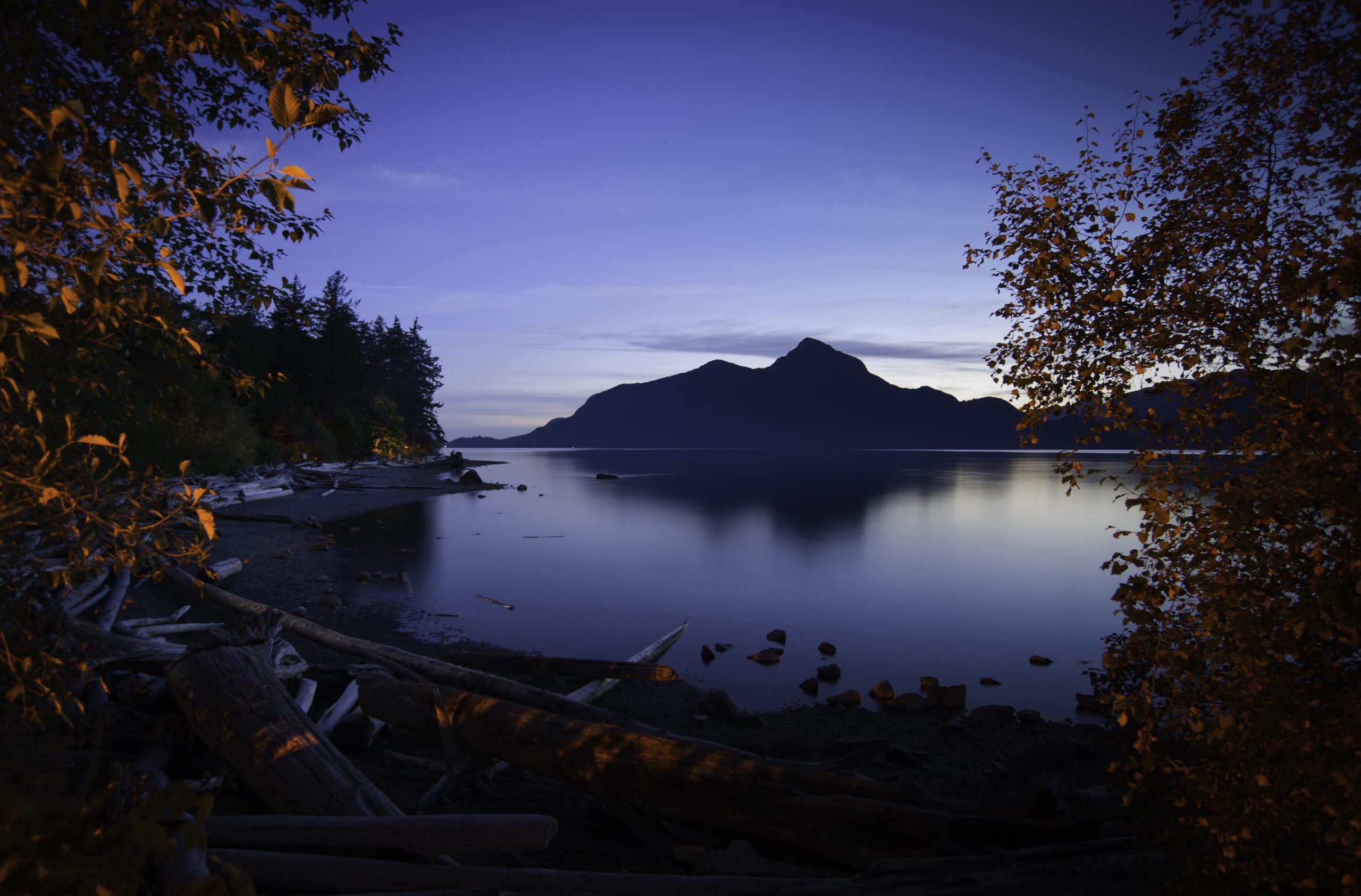 Stunning coastal view of Howe Sound from the beach at Porteau Cove Provincial Park on a still evening.