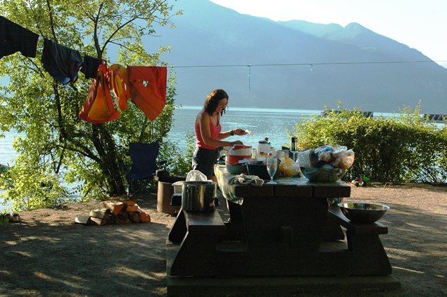 Family enjoying a picnic lunch at a designated campsite in Porteau Cove Provincial Park, surrounded by trees and coastal views.